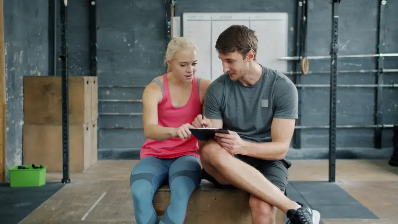 Antrenör ve sporcu tablet üzerinden antrenman planını birlikte inceliyor